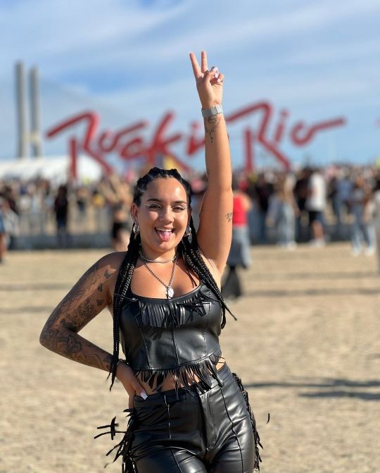 Girl weaing a matching black leather crop top and leather pants with fringe details