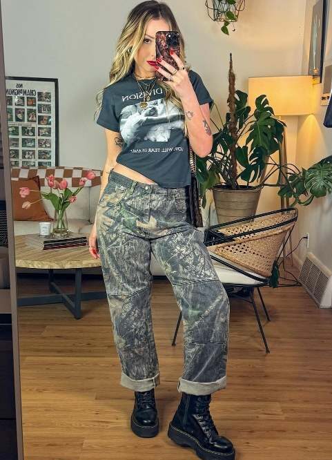 Rena wearing a high-waisted, loose-fitting camouflage pants with black graphic t shirt