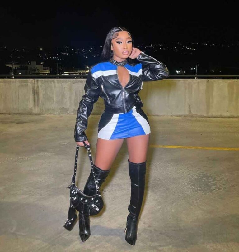 crystal wearing a half-zipped black and blue leather jacket and a matching mini-skirt