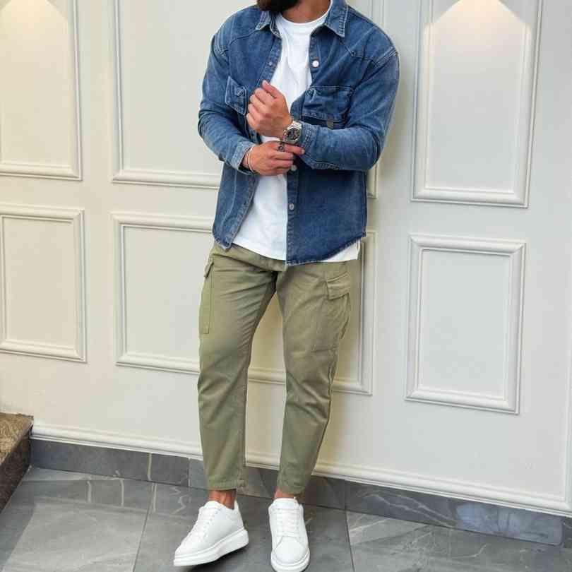 Guy wearing a denim shirt over a white t shirt with olive green cargo pants and white sneakers