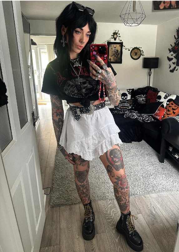 Amy wearing a black graphic crop top with white ruffled skirt