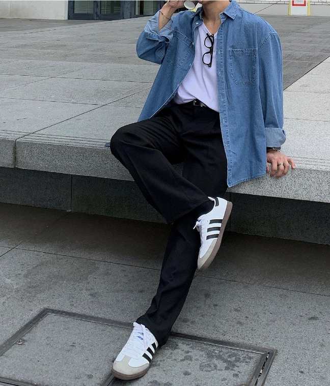 Guy wearing a blue denim button-up shirt over a white t shirt and black pants