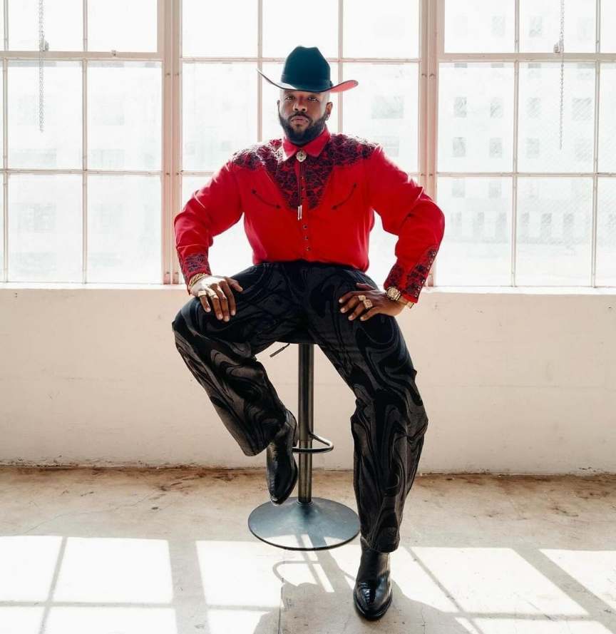 Guy wearing a bright red button-up with fancy black embroidery with black pants