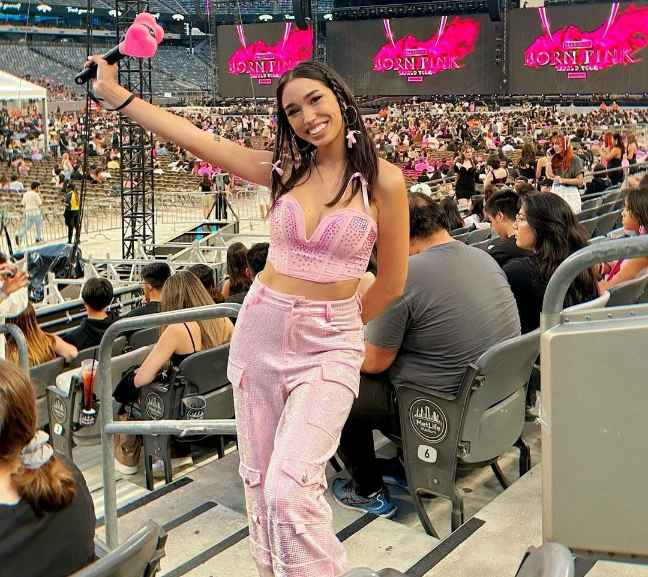 Jolene wearing a pink, strapless, bustier-style crop top with pink cargo pants