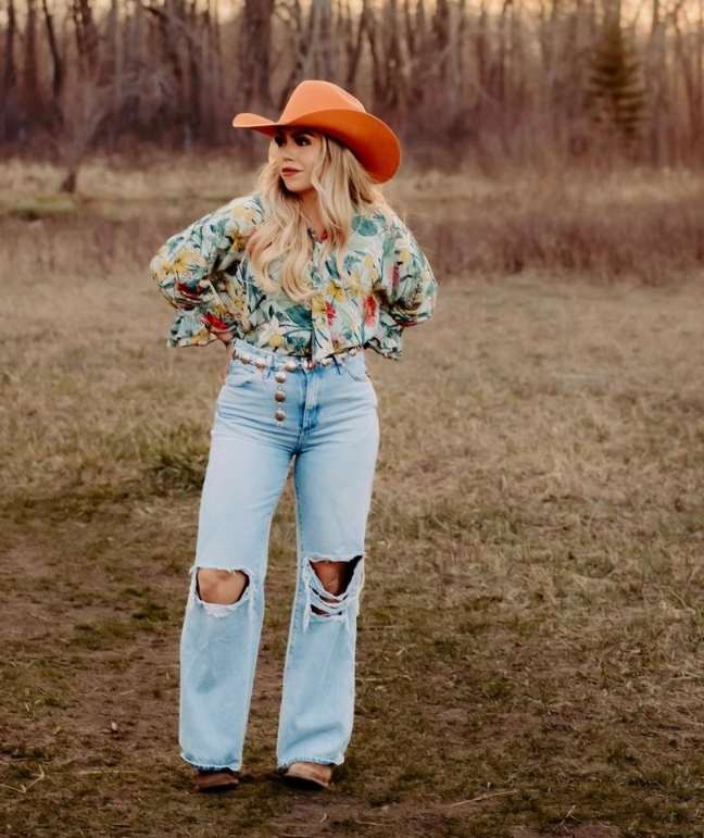 Kayla wearing a long-sleeve floral blouse with ripped light blue jeans