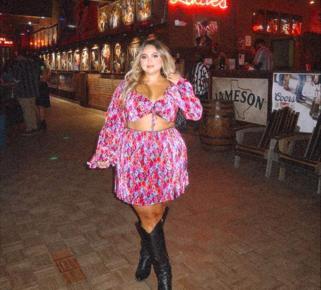 Liz wearing a a colorful, floral-patterned two-piece dress