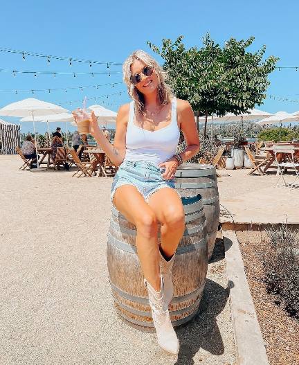 Michelle wearing a classic white tank top with light blue denim jeans