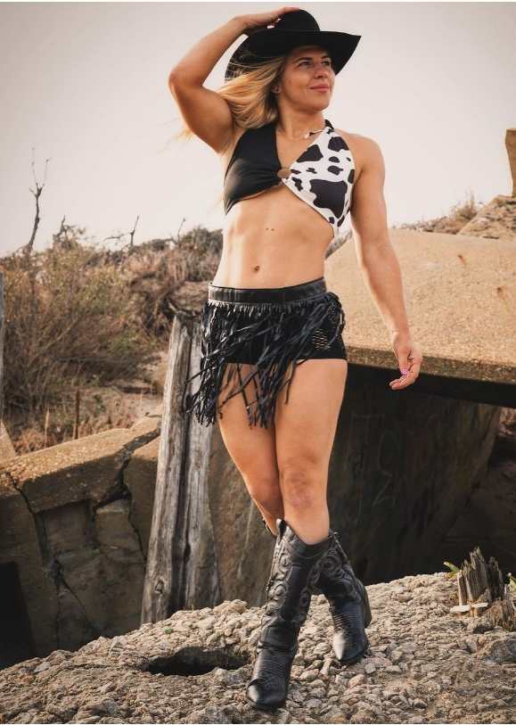 Miranda wearing a black and white a cow-print halter top paired with some sassy black fringe shorts