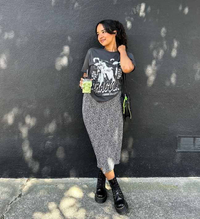 Zaire wearing a graphic tee with black and white patterned midi skirt