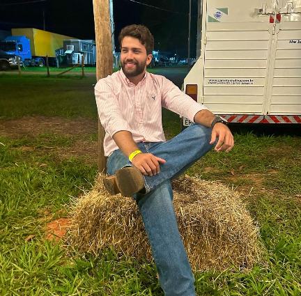 Andre wearing a pink-striped button-up shirt with dark blue jeans