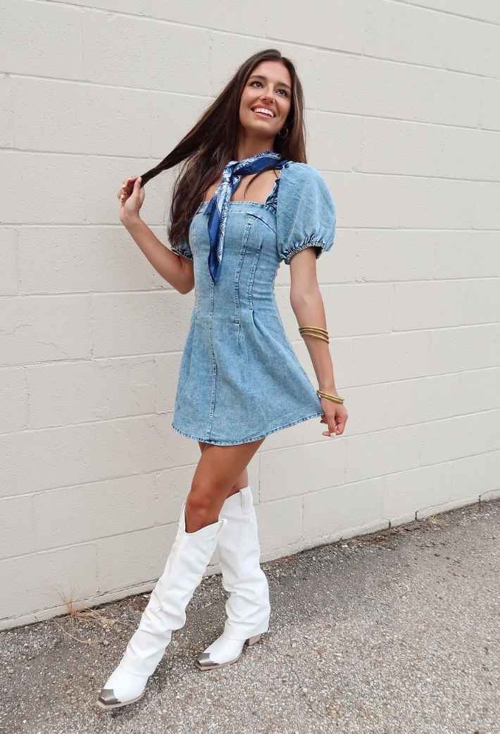 Girl wearing a short denim dress with puffy sleeves