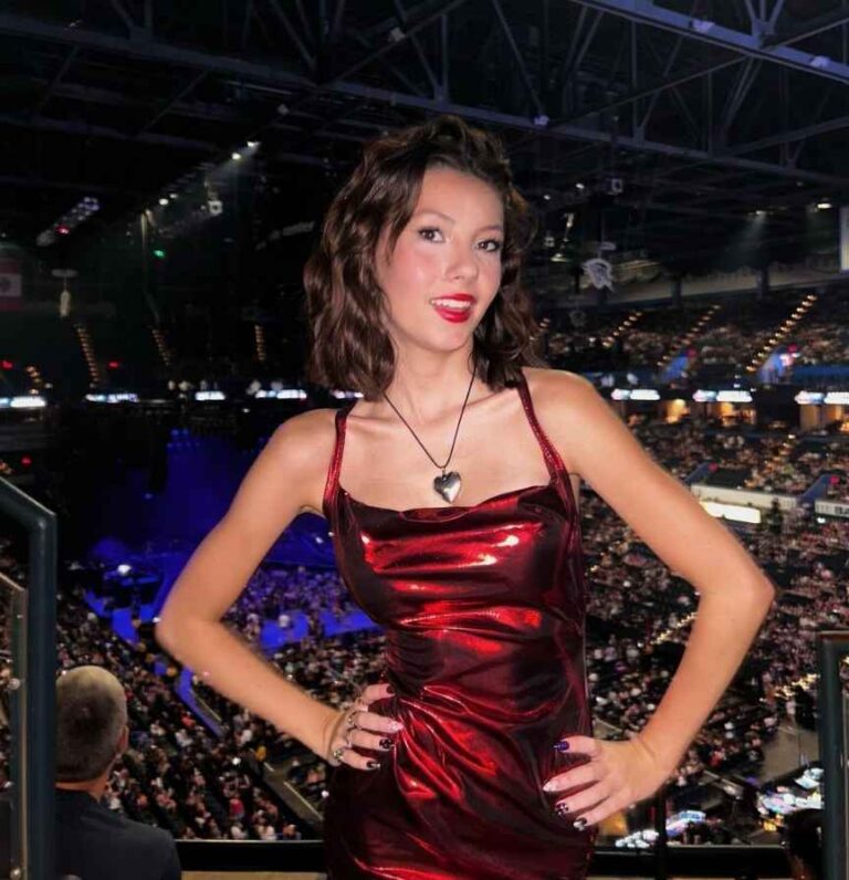 Hannah wearing a shiny red dress with spaghetti straps