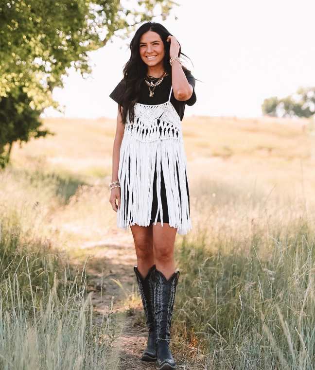 Marijka wearing a black tee and a flowy white fringed crocheted dress on top