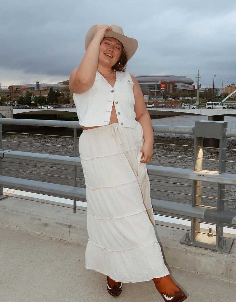 Morgan wearing a tiered long white skirt and a matching white sleeveless vest top