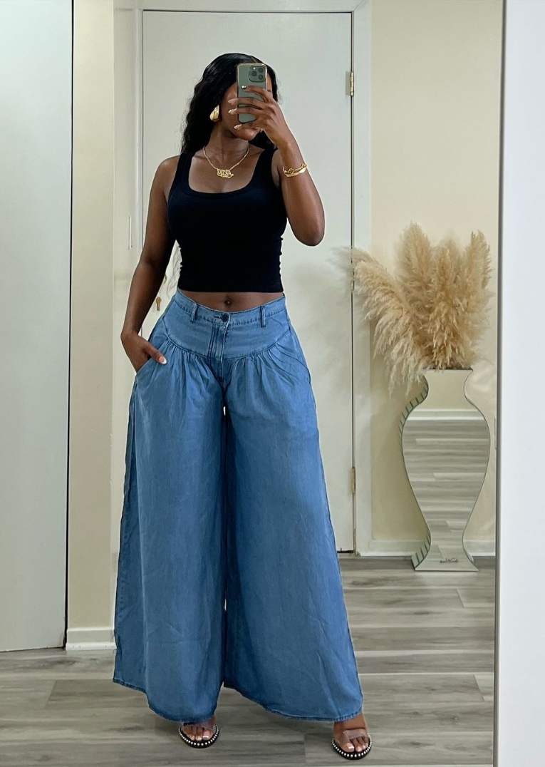 girl wearing a black fitted ribbed tank top with denim palazzo pants