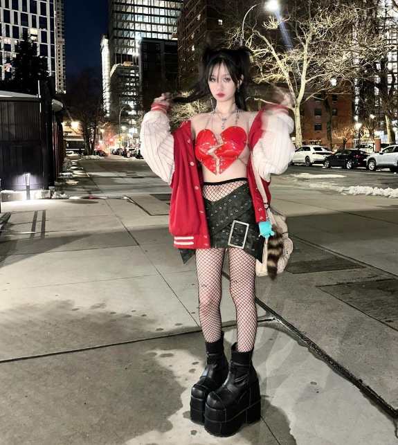 girl wearing a red broken heart-shaped bra top with black mini-skirt with silver studs