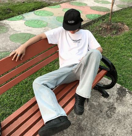 guy wearing a plain white, short-sleeve shirt with wide leg jeans