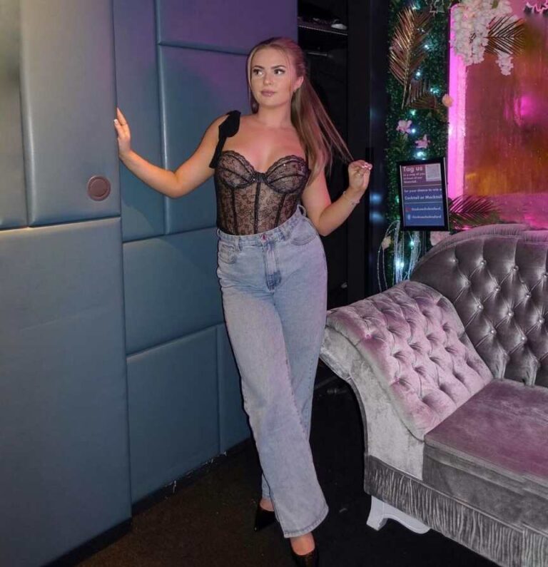 katie wearing a black lace corset top wih a light-wash, straight-leg jeans