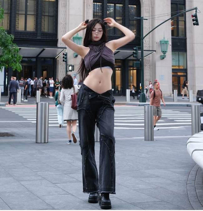 molly wearing a dark gray halter crop top hoodie worn over a black crop top with black baggy jeans