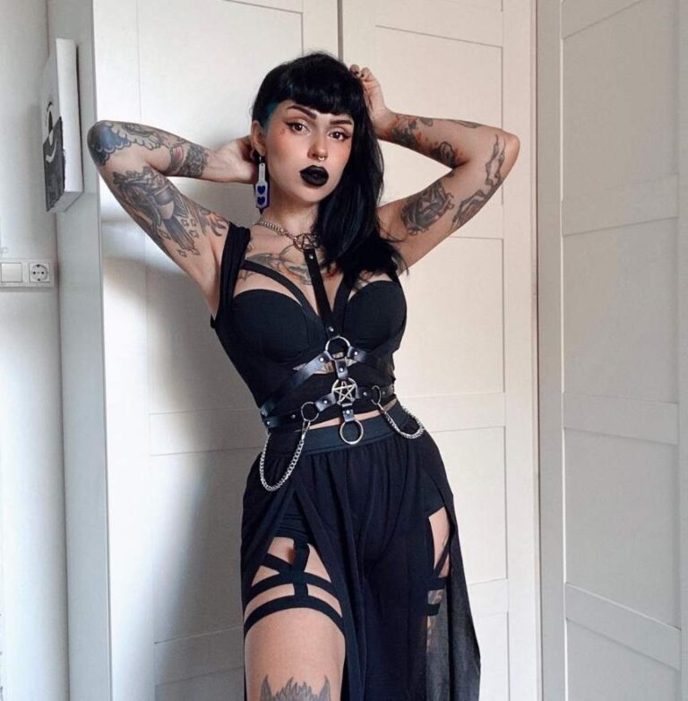 satana wearing a strappy harness on top of a black crop top paired with a flowing skirt