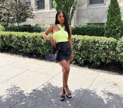 sherina wearing a light green, ribbed knit halter top with a black mini skirt