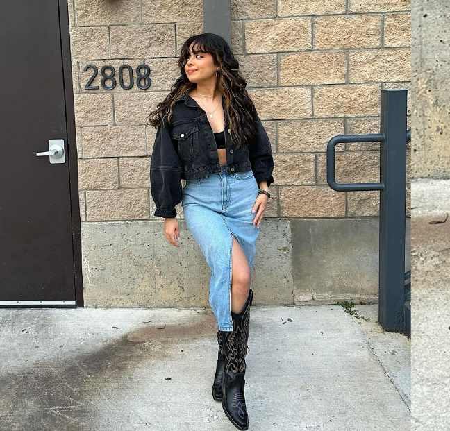 stephanie wearing a cropped black denim jacket over a black bralette and a midi denim skirt