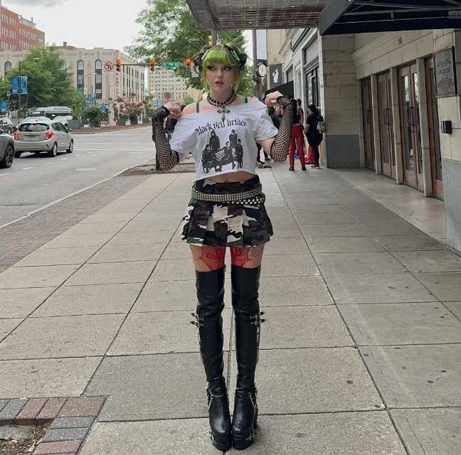 alexa wearing A cropped  off the shoulder t-shirt, camo-print skirt, fishnet gloves