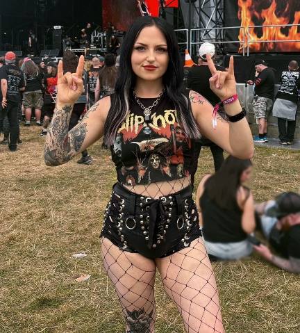 catarina wearing sleeveless cropped band t-shirt with black shorts, fishnet stockings, and metal hardware