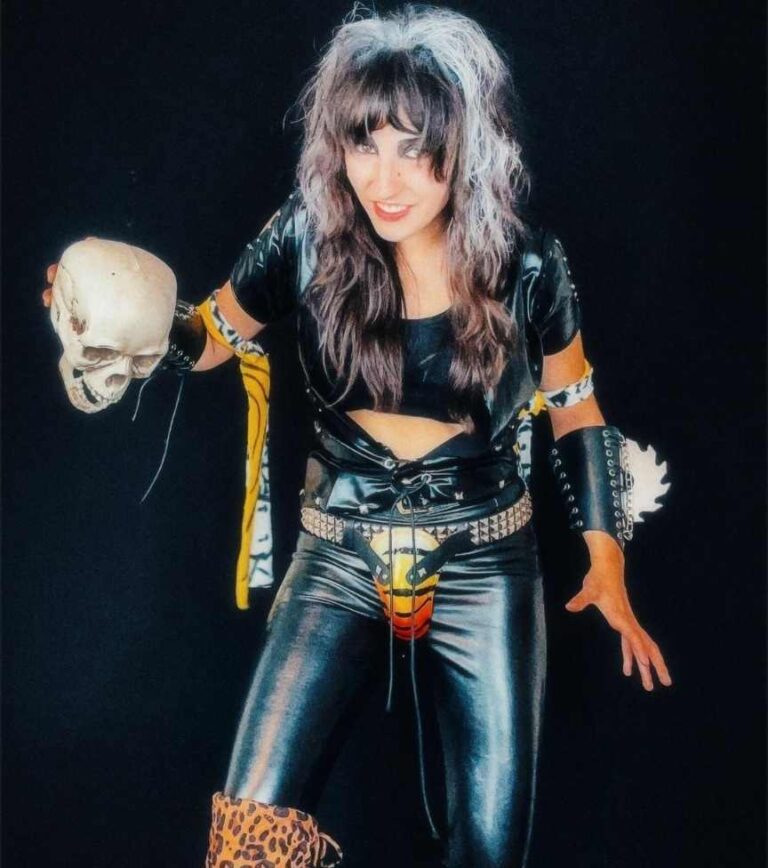 maddi wearing a black leather jumpsuit decked out in studs, belts