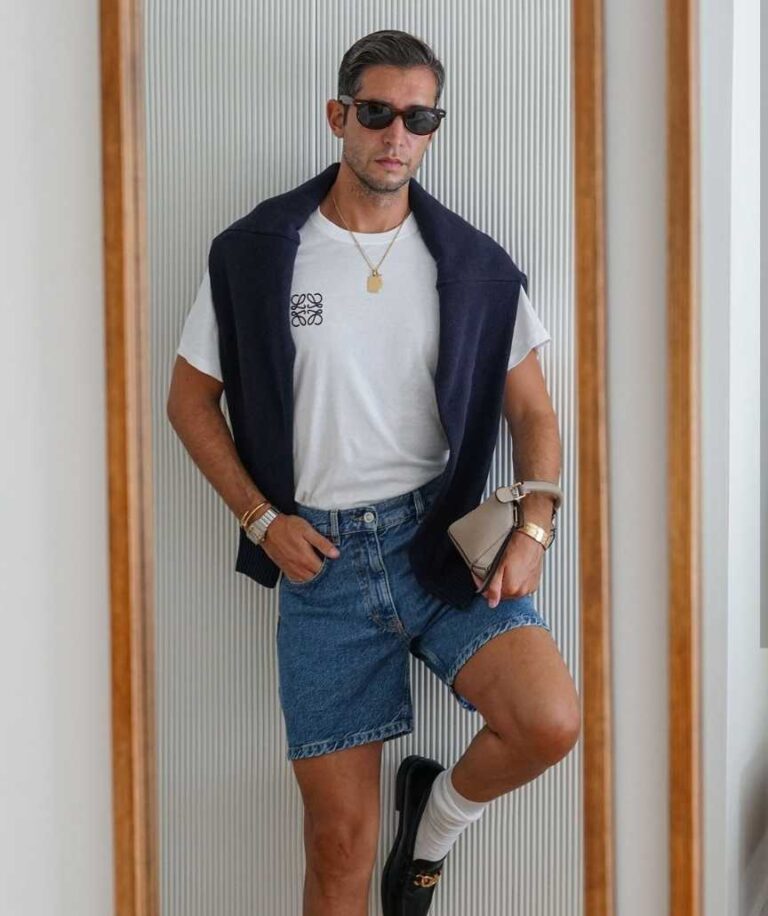 eduardo wearing a white T-shirt with a navy sweater draped over your shoulders Paired with denim shorts