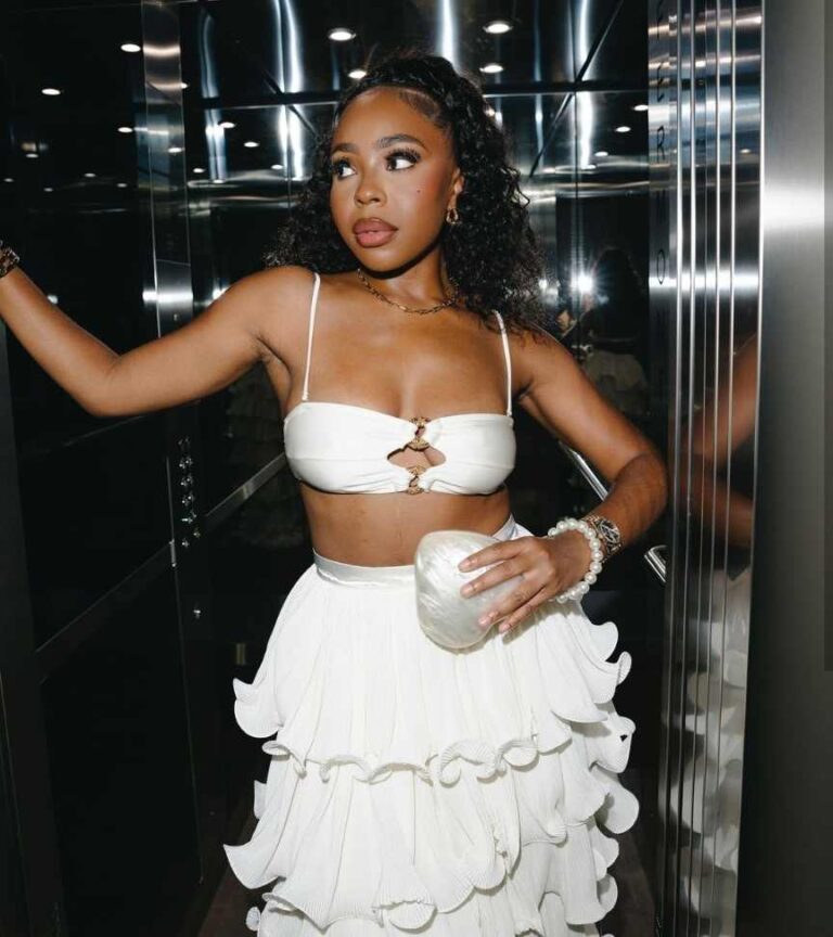 girl wearing white spaghetti strap bralette top paired with a knee-length white skirt with ruffles