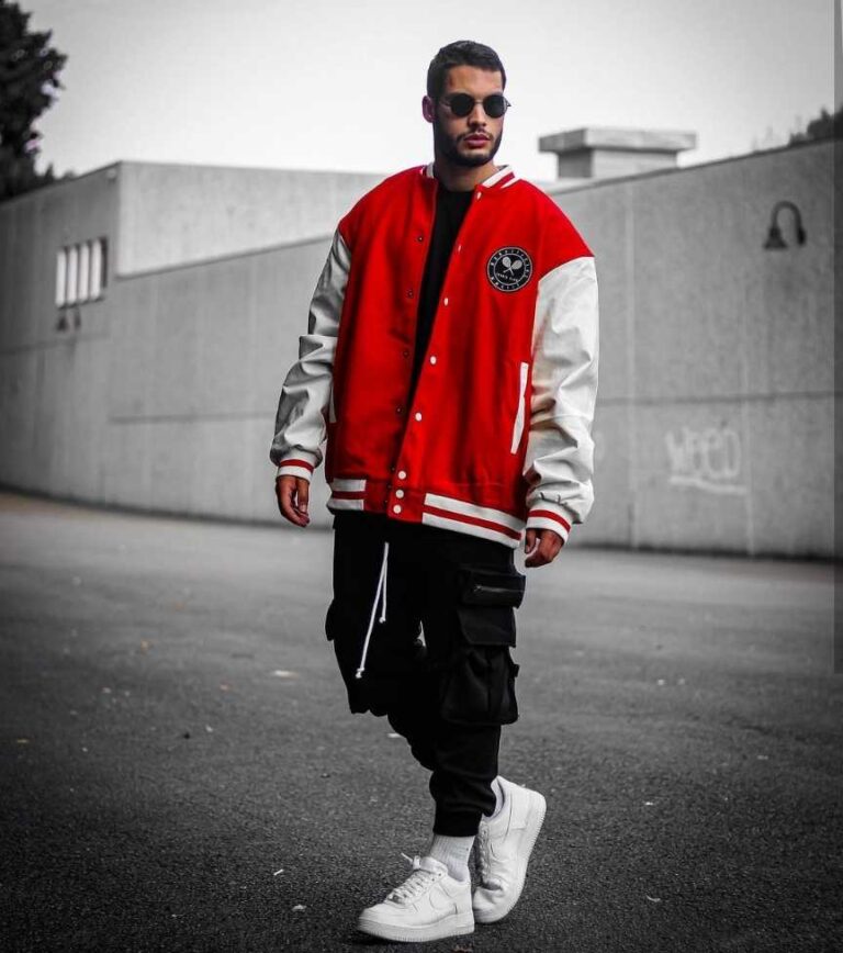 guy wearing a classic red and white oversized varsity jacket over a black T-shirt with cargo pants