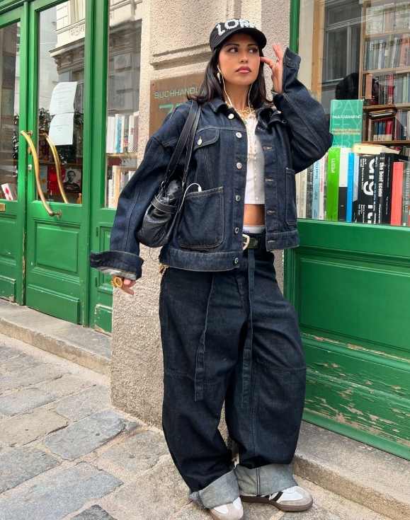 kiana wearing an oversized dark blue denim jacket layered over a snug white crop top with baggy denim pants