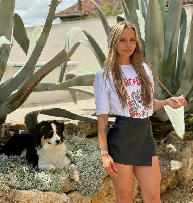 lucie wearing a band tee tucked into a black leather mini-skirt