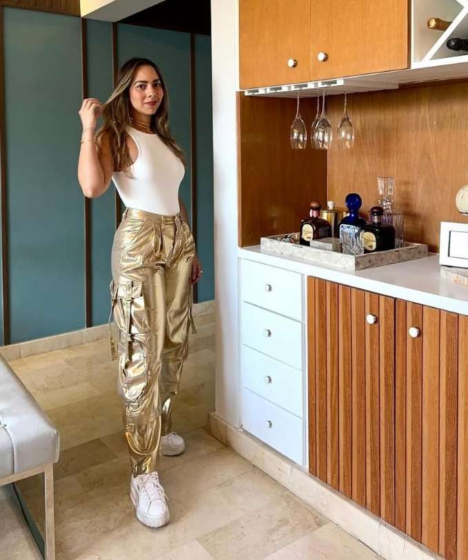 ally wearing metallic gold cargo-style pants and a fitted white sleeveless tank top