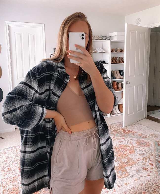 girl wearing A black-and-white plaid oversized flannel over a neutral-toned crop top with Soft drawstring lounge shorts