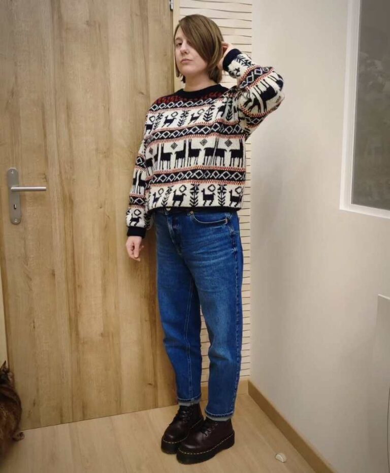 girl wearing A festive patterned sweater with straight-leg blue jeans and brown doc martens