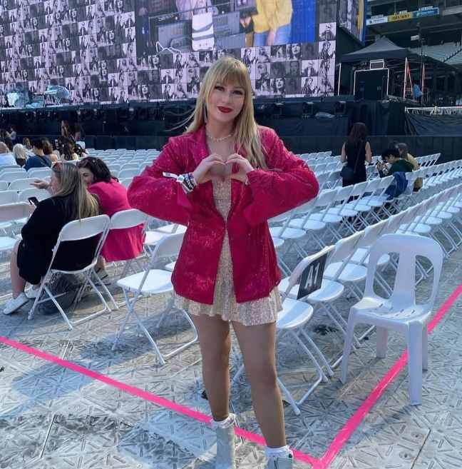 girl wearing a short champagne-colored glittery dress layered with a bright pink sequined blazer