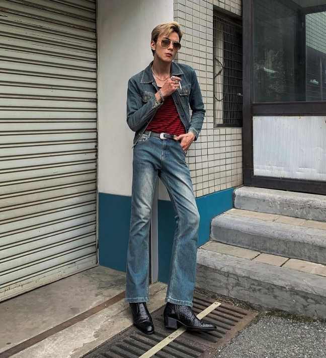 guy wearing a light-wash denim jacket over a red and black striped fitted t-shirt paired with matching light-wash flared jeans