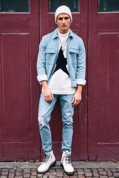 guy wearing light-wash ripped jeans with a matching denim overshirt and a graphic tee and white doc martens