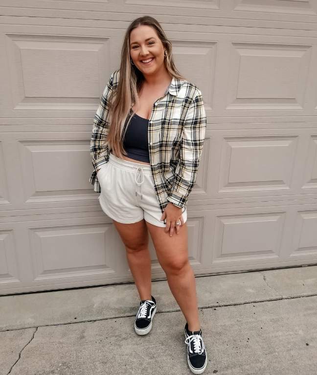 kait wearing A yellow and black oversized plaid flannel over a dark cropped tank top and Cream-colored drawstring shorts