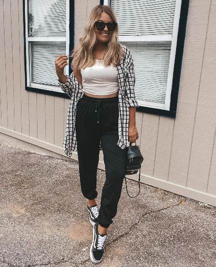 katie wearing A lightweight black-and-white oversized flannel layered over a white cropped tank top with Black joggers