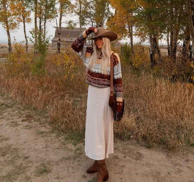 kira wearing a warm-toned patterned sweater with a cream maxi skirt