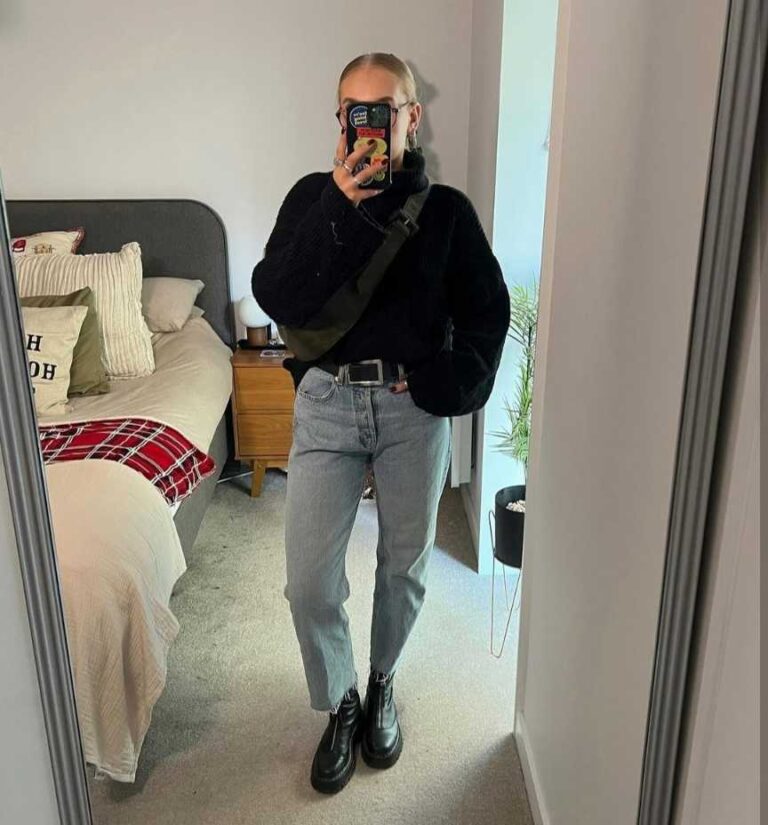 lucy wearing An oversized black turtleneck sweater with Wide-leg light-wash jeans and platform Doc Martens