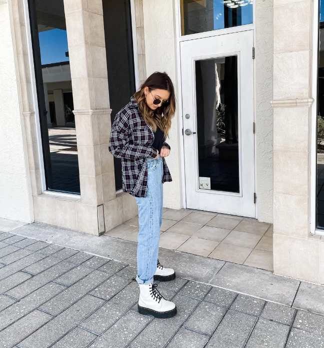 melissa wearing a classic oversized flannel shirt over a fitted black top with light wash jeans and white doc martens