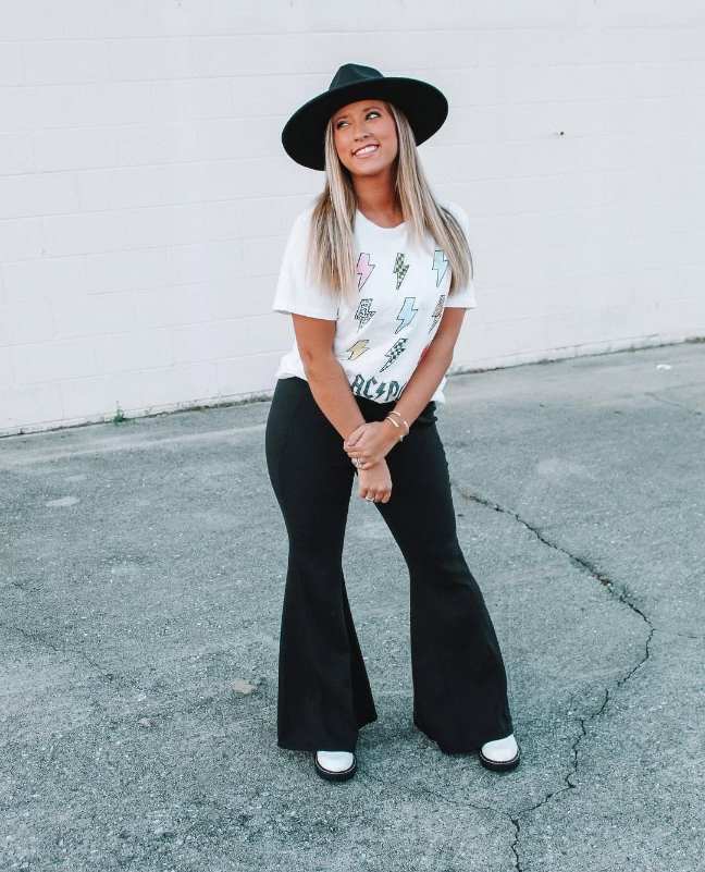 melissa wearing a fun graphic tee with black flared pants and white doc martens