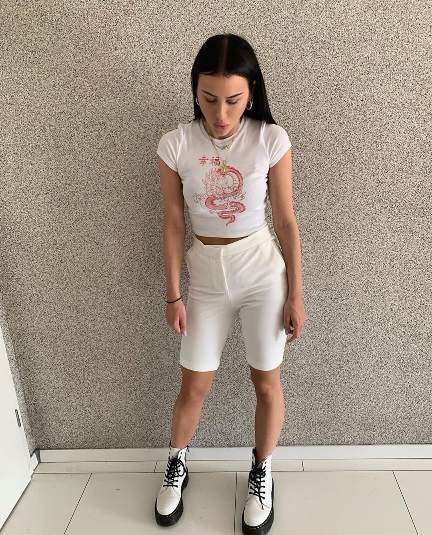 natali wearing a graphic crop top and White Bermuda shorts with doc martens