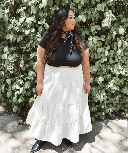 plus size girl wearing a fitted black crop top and a white tiered maxi skirt