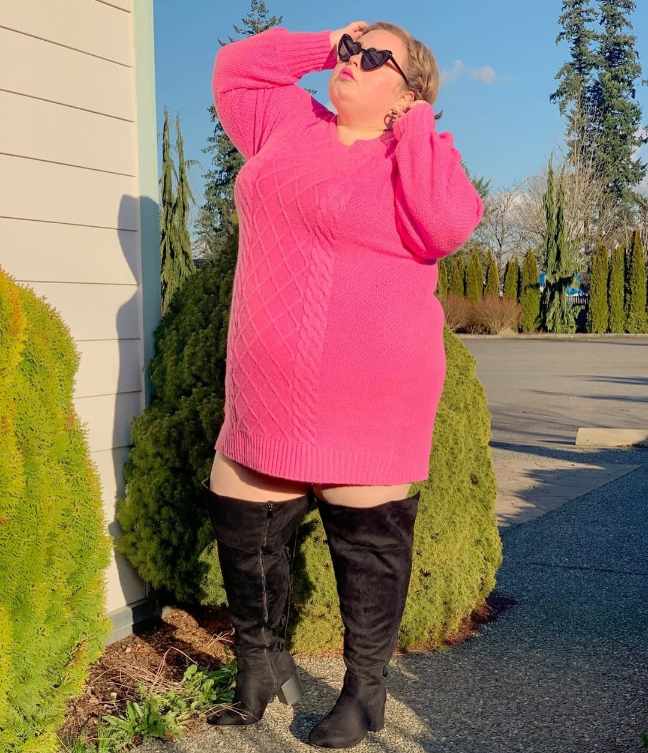 plus size girl wearing a hot pink cable knit sweater dress