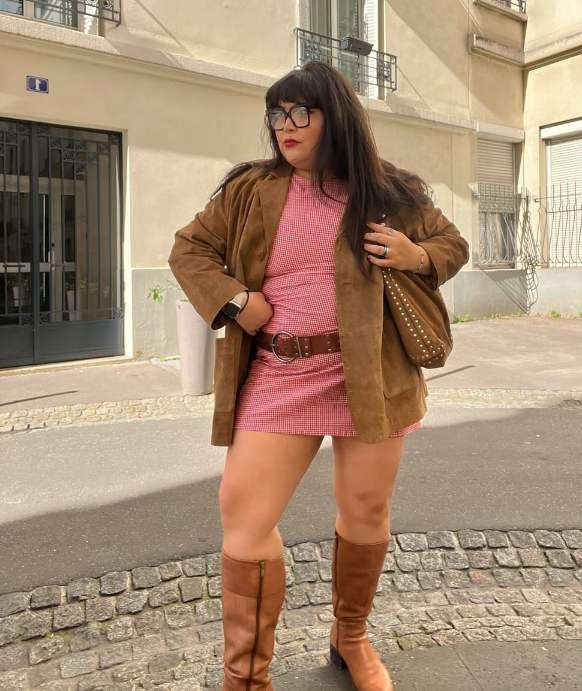 plus size girl wearing brown suede blazer over a pink gingham mini dress